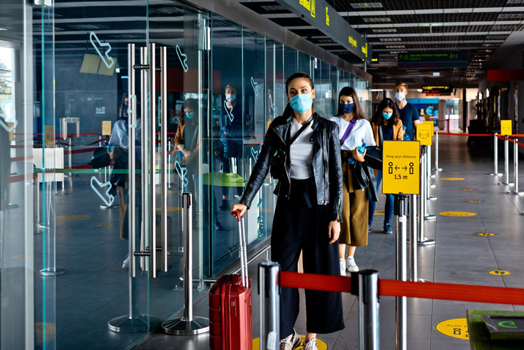 Passengers wearing N95 face masks waiting in line at an airport terminal &copy; izusek / Getty Images