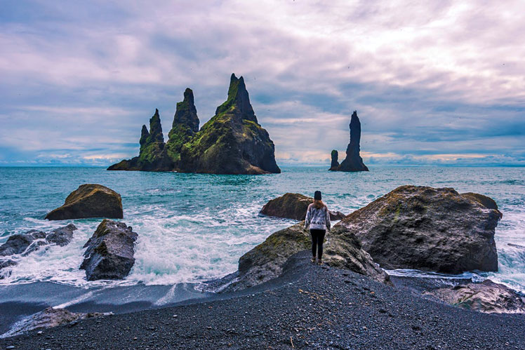 Looking out towards the Reynisdrangar basalt sea stacks from Reynisfjara Beach &copy; Sasha64f / Shutterstock