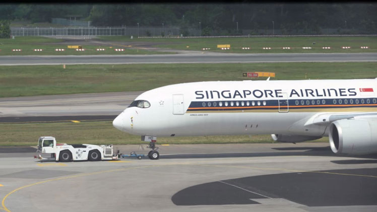 A Singapore Airlines passenger plane is towed to the terminal area of Changi International Airport on December 7, 2020. 